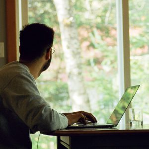 An image of a man working at his laptop from home. Photo by Yasmina H.